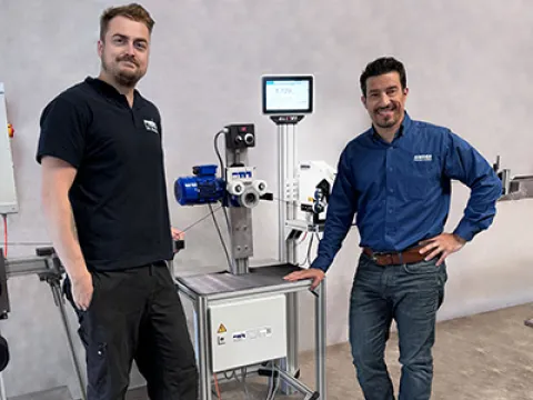 Michael Kinnart, Technischer Leiter bei der PMH GmbH, mit Aguinaldo Ramalho, Head of Sales – Wire & Cable, an der Filamentanlage mit dem integrierten Durchmessermesskopf und Knotendetektor, Bild: Sikora Übergabe der Filamentanlage mit integriertem Durchmessermesskopf und Knotendetektor